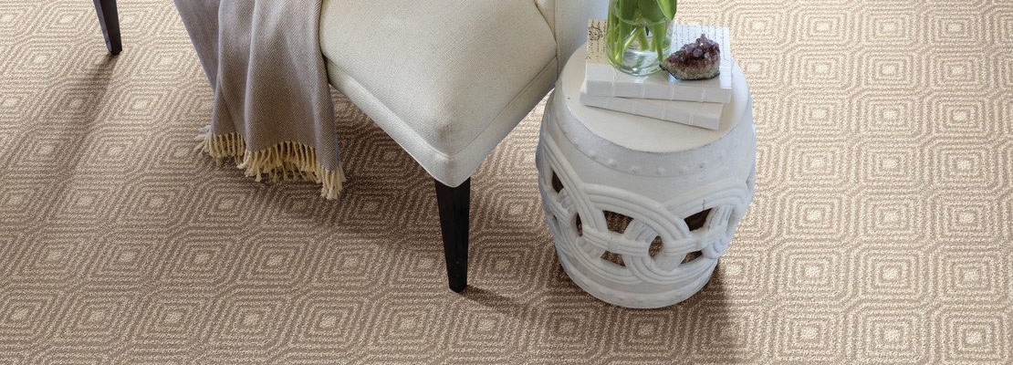 Tan patterned carpet with white chair and white stone table